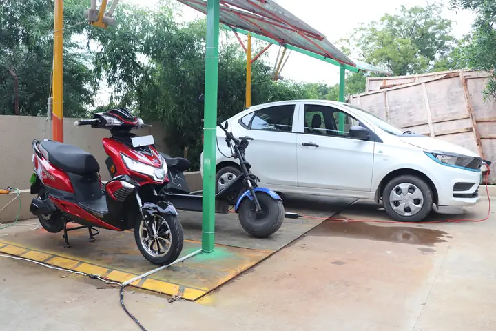 Electric car and scooters charging under a solar carport